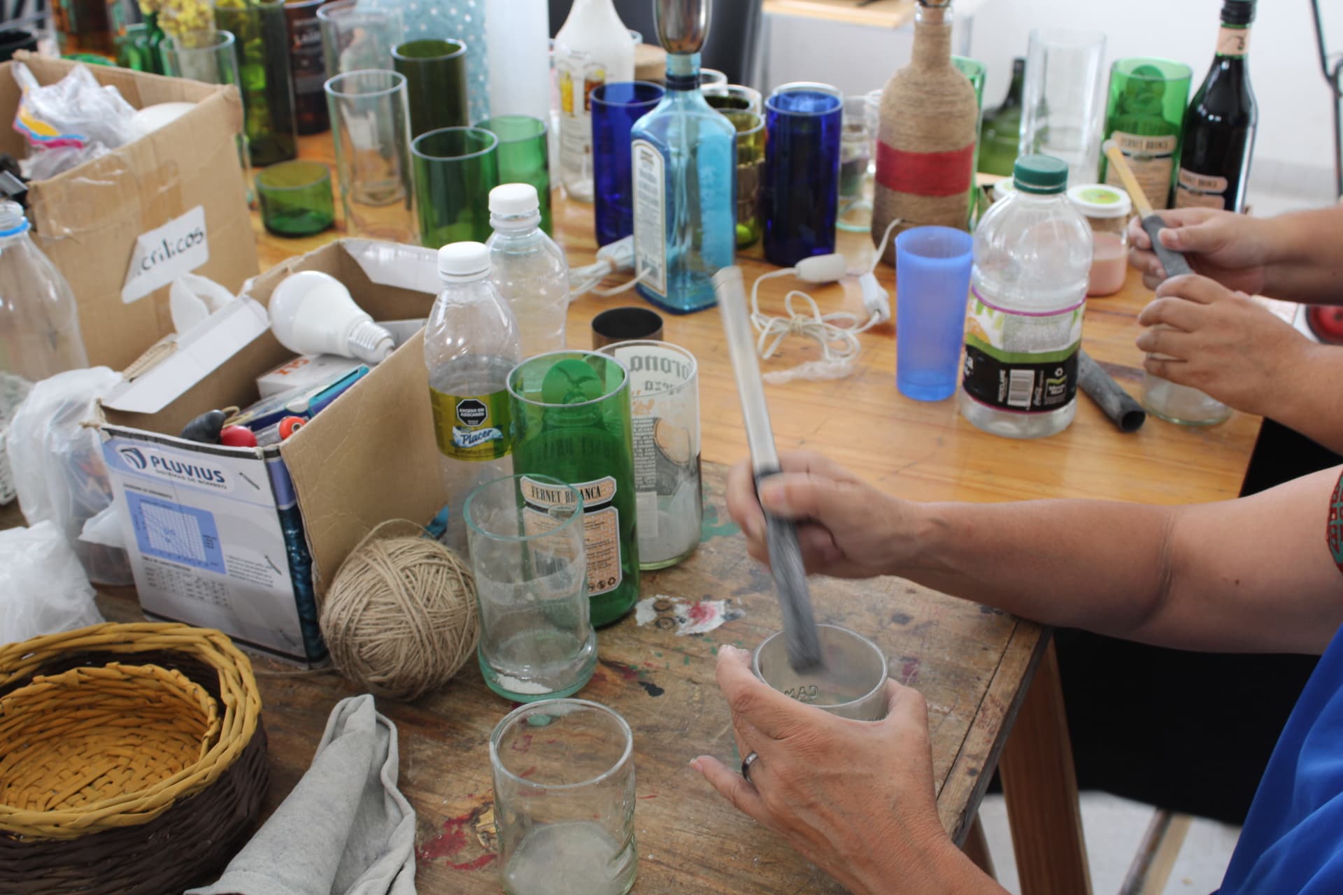 Manos trabajando con botellas recuperadas